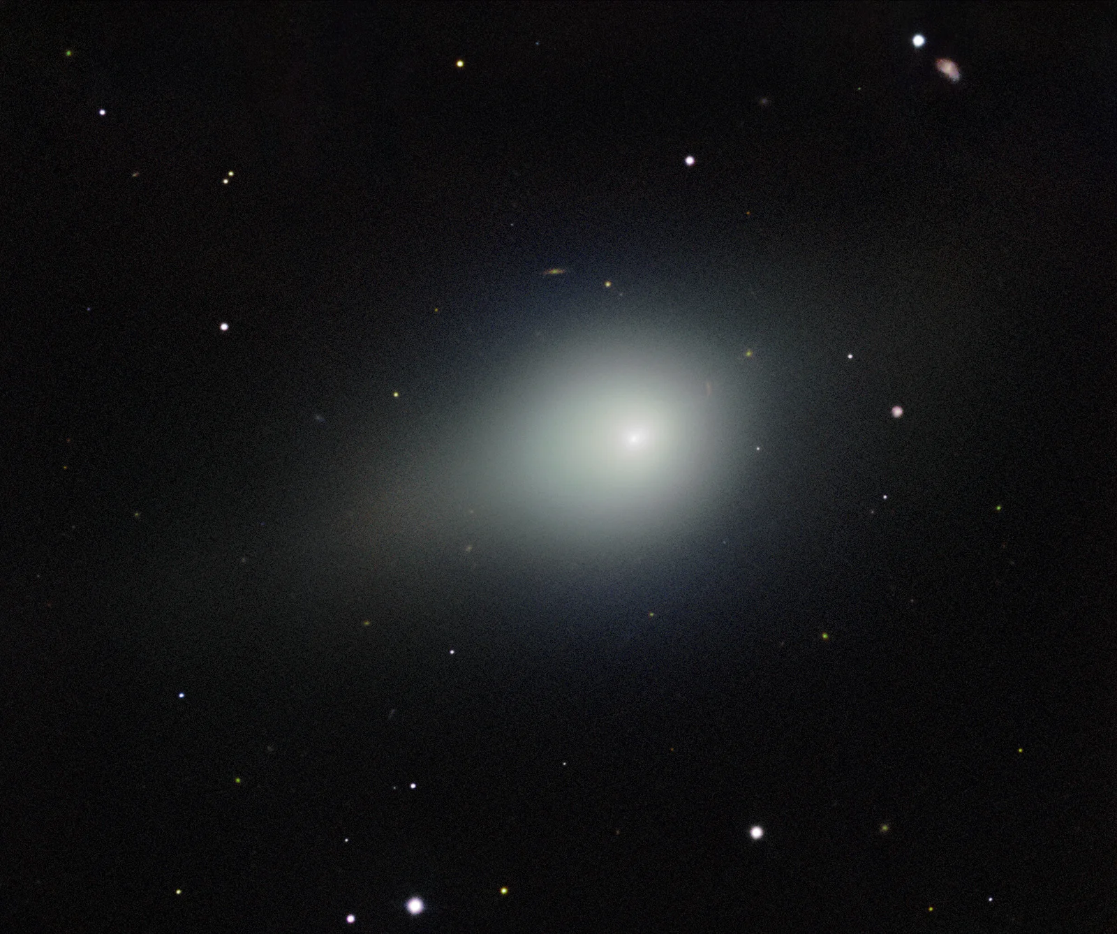 A small pale-blue comet and diffuse coma against a dense star field, imaged by Gemini North; a faint main-belt asteroid appears lower right.
