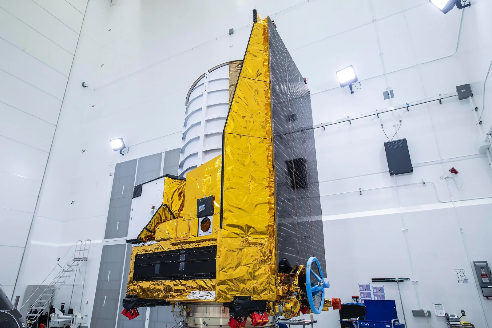 Le vaisseau spatial Euclid dans une salle blanche avant son lancement, avec des panneaux solaires noirs sur un côté et le cylindre blanc du télescope au-dessus du module d'instruments.